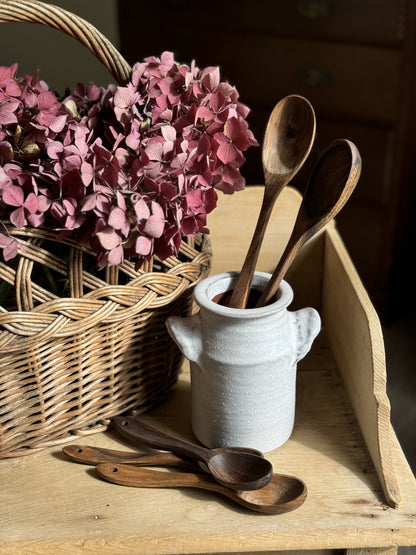 Hand carved wooden spoons in walnut wood in vintage ceramic jar